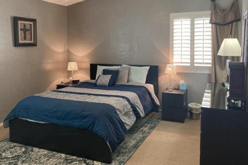 嘉年Good Memories in Goodyear的一间卧室配有一张大床,提供蓝色的床单和枕头