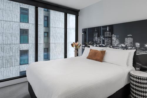 墨尔本Imagine Southbank的卧室设有一张白色大床和大窗户