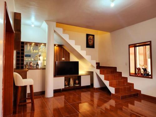乌鲁班巴El Rey Lobo Casa de Campo Valle Sagrado的一间带楼梯和电视的客厅