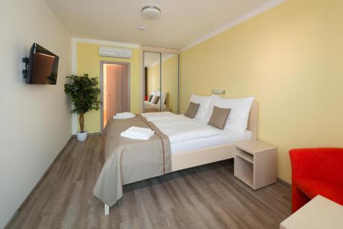 大梅济日奇OC Panorama的卧室配有一张白色大床和红色椅子