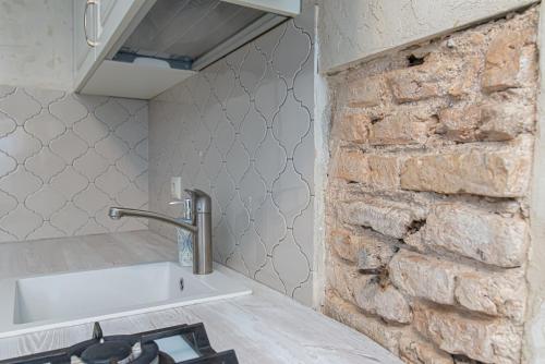 维尔纽斯Luxury apartment in Pilies street的厨房设有水槽和砖墙