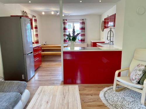 费尔德基兴Lendorfer Cottage的厨房以及带红色橱柜的起居室。