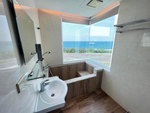鹅銮鼻享念海湾海景民宿的一间带水槽和大窗户的浴室