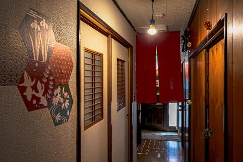 东京Wabi Sabi Hostel的走廊上设有红色墙壁和门