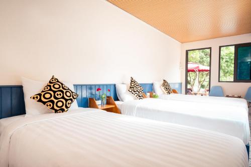 吉婆岛Catba Papillon Garden Bungalows & Resort的带窗户的客房内的2张白色床
