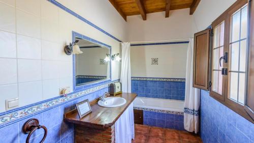 AlmogíaCasa Loma el Letrao Almogia by Ruralidays的蓝色和白色的浴室设有水槽和浴缸。