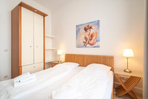 赛巴特班森Villa Frohsinn Appartement 09的卧室配有一张床,墙上挂有绘画作品