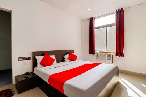 BhiwadiOYO Flagship 80902 Swagat Hotel的一间卧室配有一张带红色枕头的大床