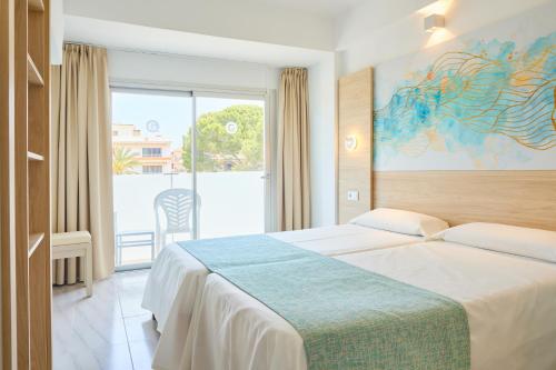 卡拉纳雅达Hostal Gami Adults Only的酒店客房设有一张床和一个大窗户