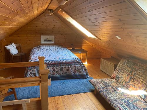 GoleenMuckle Flugga的小木屋内一间卧室,配有一张床和一张沙发