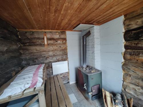 KaresuvantoVilla Lavijoki的小房间设有一张床和炉灶