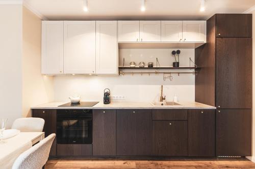 弗罗茨瓦夫Pure Rental Apartments的厨房配有白色橱柜和水槽