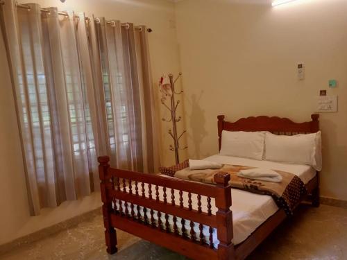 阿勒皮Sinai Homestay的一间卧室设有一张木床和一个窗户。