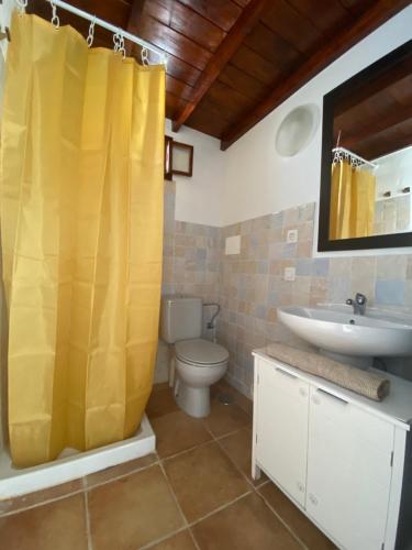 宏达海滩HAPPY HOUSE NANE的浴室设有黄色的淋浴帘和水槽