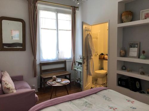 达克斯La Croix Blanche的一间卧室配有一张床、一张桌子和一个窗户。