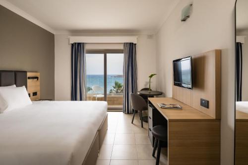 圣保罗湾城QAWRA Palace Resort & SPA的酒店客房设有一张床,享有海景。