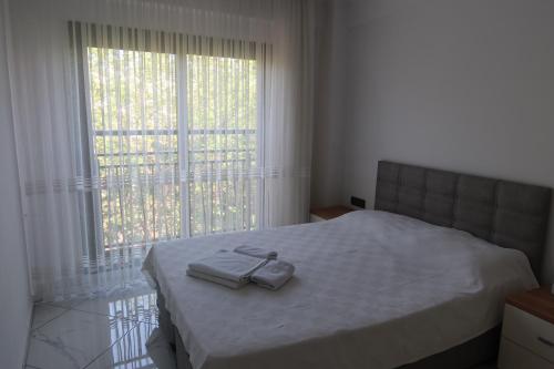 库萨达斯MAYA APARTMANI的一间卧室配有一张床,上面有两条毛巾