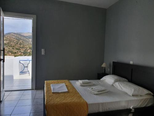 锡基诺斯岛Galini Rooms Sikinos Travel的一间卧室配有一张桌子和一个阳台。