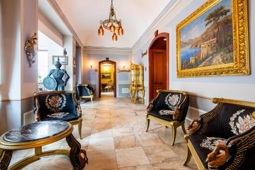 Hernádvécse维塞斯城高级酒店的客厅配有椅子和墙上的绘画