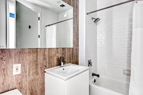 纽约Tribeca 1BR w Gym Doorman Roof deck NYC-54的一间带水槽、浴缸和镜子的浴室