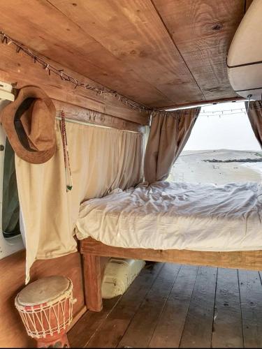 罗萨里奥港Gipsy Van Fuerteventura的一张位于带桌子的房间后面的床