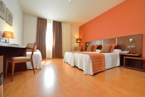 拉林Hotel Spa Norat Torre Do Deza 4* Superior的酒店客房配有两张床和一张书桌
