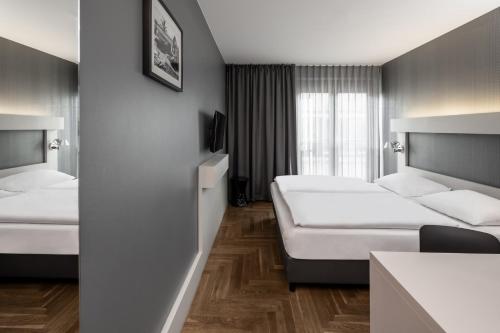 柏林Hotel AMANO Rooms & Apartments的酒店客房设有两张床和窗户。