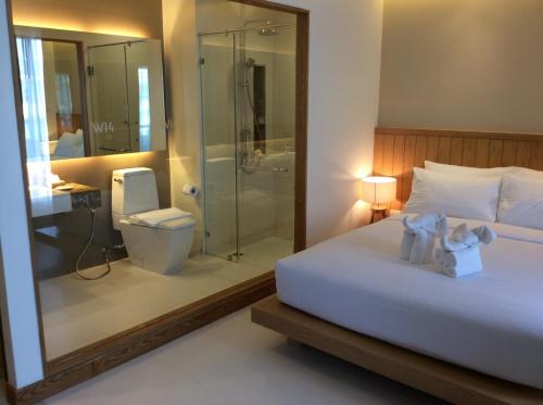 南芭堤雅W14芭堤雅酒店的一间卧室设有一张床、淋浴和卫生间