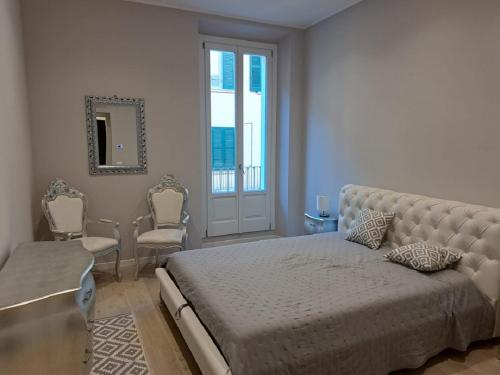 布雷西亚典雅之家公寓的一间卧室配有床、椅子和窗户