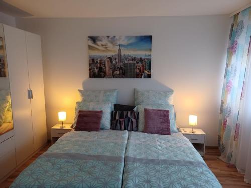 巴登-巴登H&A Apartment Baden Baden的一间卧室配有一张带两盏灯的蓝色床。