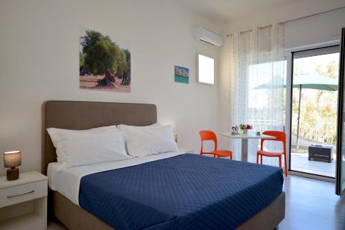 Villaggio RestaCamera & Caffè - Accoglienza Salentina的卧室配有一张床和一张桌子及椅子