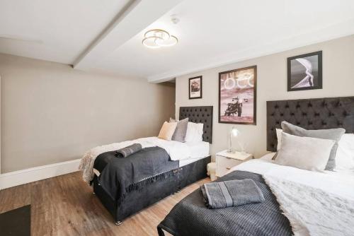 韦克菲尔德Beautiful 2 Bedroom Apartment in Central Wakefield的一间卧室配有两张床和椅子