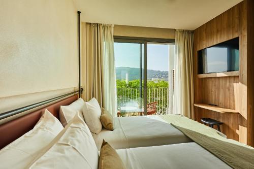 普拉加德阿罗Silken Platja d'Aro的酒店客房设有一张床和一个阳台。