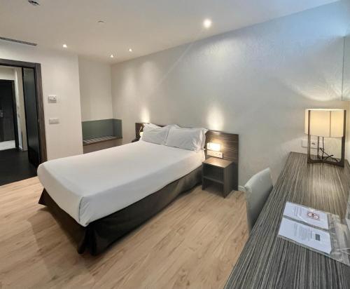 马德里HelloSky Air Rooms Madrid的卧室配有白色大床和灯