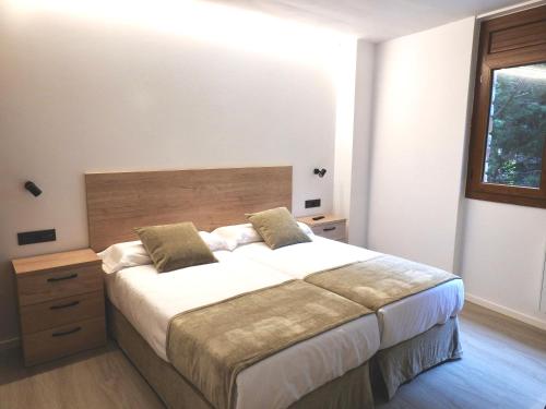 奥尔迪诺Apartaments Turistics El Buner的一间卧室设有一张大床和一个窗户。