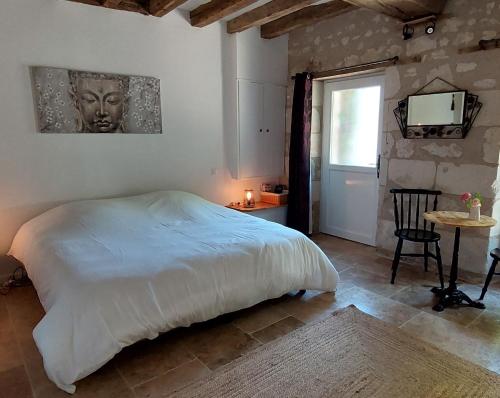 Parçay-les-PinsLe Clos des Roses的一间卧室配有一张床、一张桌子和一台电视