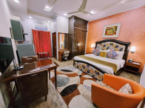 拉合尔Hayyat Luxury Suites的一间卧室配有一张床、一张书桌和一台电视。