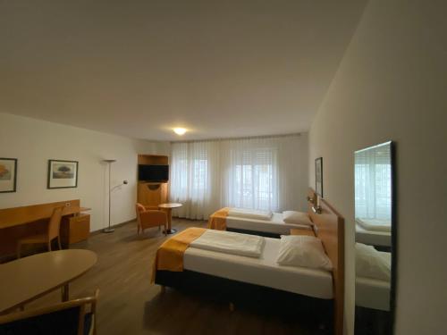 曼海姆阿里瓦博丁普拉塔南花园住宅酒店的酒店客房设有两张床和一张桌子。