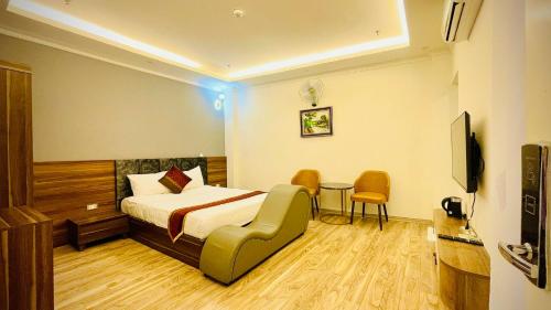 河内Win Villa Hotel & Apartment的酒店客房带一张床、一张桌子和椅子
