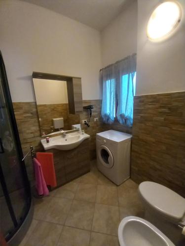 贡内萨Domus Shardana的一间带水槽、卫生间和镜子的浴室