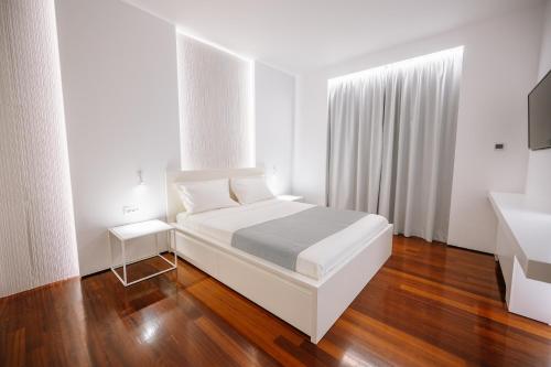 卡特罗斯BlueGreen Villa的白色卧室设有白色的床和木地板