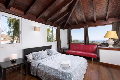 拉奥利瓦Home2Book Ocean Surf House Fuerteventura的一间卧室配有一张床和一张红色椅子