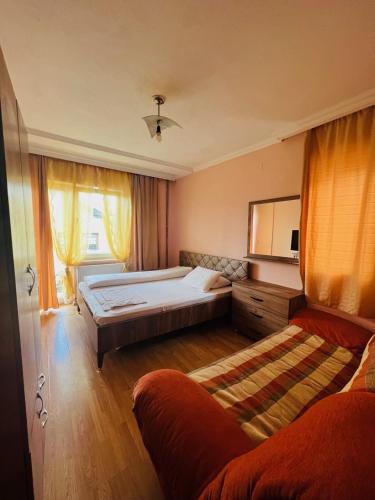普里什蒂纳Guest House Velania的一间卧室配有一张大床和一张沙发