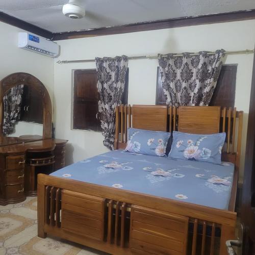 NgamboBaraste zanzibar的一间卧室配有一张大木床和蓝色床单