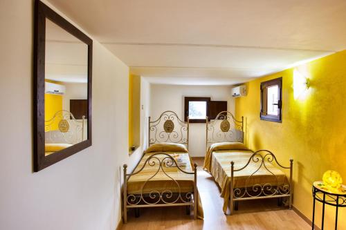 Collepasso佩拉德尔苏德住宿加早餐旅馆的黄色墙壁客房的两张床