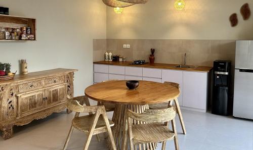 塞隆贝拉纳克Pandan Villas的厨房配有木桌和冰箱。
