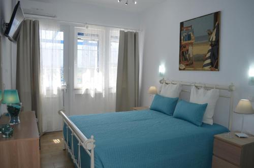 波罗斯Rania Bella Vista Studios的一间卧室配有蓝色的床、蓝色床单和窗户