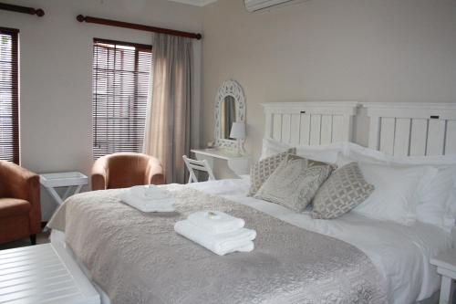 昆斯敦Cozi Corner的卧室配有白色的床和2条毛巾
