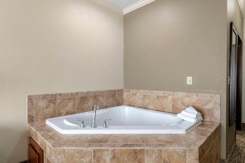 沃思堡Comfort Inn & Suites Fort Worth - Fossil Creek的带浴缸的浴室和瓷砖墙