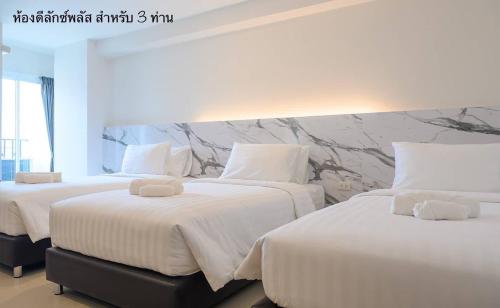 曼谷Donmueang Place Hotel - SHA Plus的配有白色床单的酒店客房内的两张床